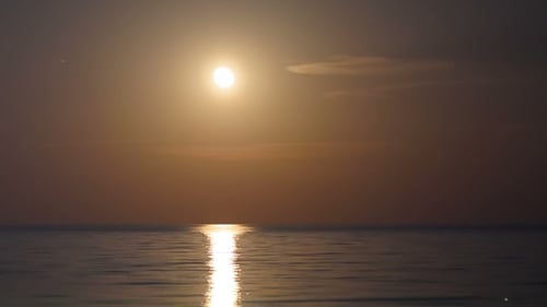 Vollmond geht über dem Meer und dem Mondweg auf