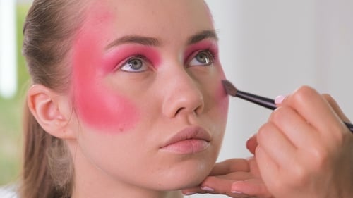 Makeup Artist Applying Pink Makeup to Young Woman