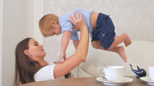 Mother Lifts Toddler in Air at Home