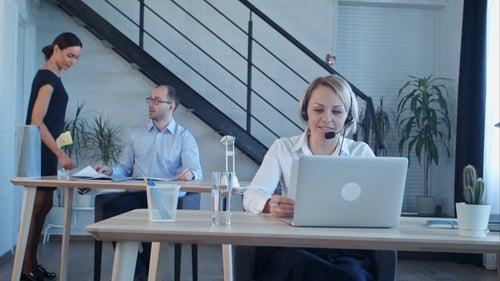 Beautiful Call Center Agent Having Phone Call and Browsing the Internet on Her Computer