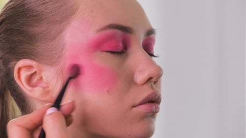 Eye Makeup Artist Applying and Feathering Eyeshadow Powder. Beautiful Woman Model Face. .