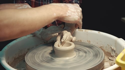 Hands Guiding Pottery on a Wheel
