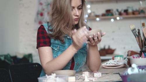 Young Woman Creates a Plate of Clay in the Workshop. Girl Holding a Shape of Clay in Her Hands