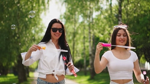 Two Beautiful Young Girls in Sexy Clothes Are Laughing and Dancing While Riding a Segway in the Park Two Beautiful Young Girls in Sexy Clothes Are Laughing and Dancing While Riding a Segway in the Park