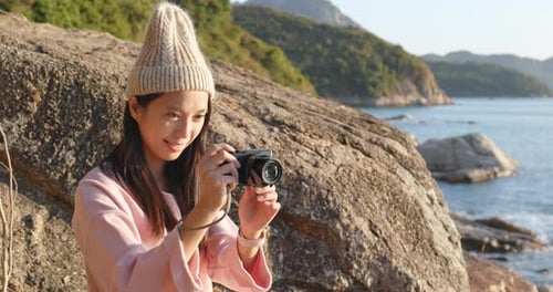 Femme prenant une photo par caméra à la campagne