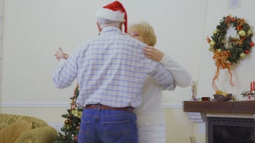 Senior Couple Dancing and Exchanging Ring at Christmas