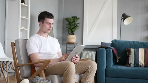 Man Receives Good News on Tablet, Celebrates