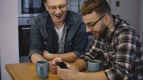 Two Young Adults Sharing Smartphone at Home
