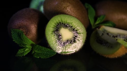 Fruits of Juicy Kiwi Rotate on a Table on a Black Background.