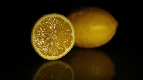Halved Lemon Displayed on Black Reflective Surface