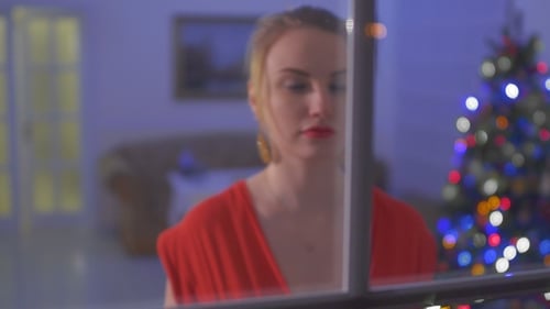 Beautiful Gilr in Red Dress Come To Window and Touch a Glass with Finger