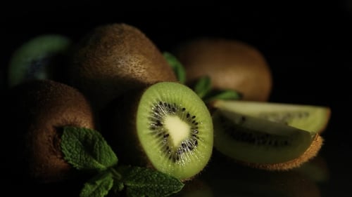 Delicious Juicy Fruit Kiwi and Mint Lie on a Black Table. Reflection of Kiwi From the Table. Pieces