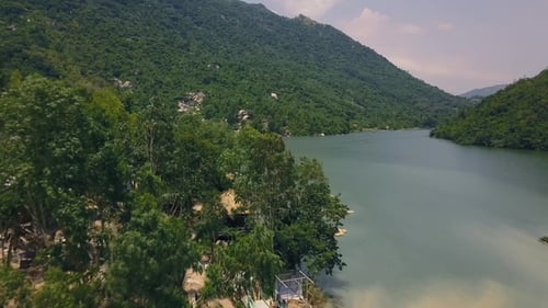 Beautiful Mountain River and Building on Shore Aerial View. Road in Green Mountain Drone Shoot