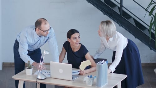 Colleagues Collaborate in Modern Office on Laptop