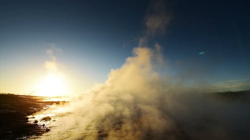Eruption of Geyser in Iceland. Winter Cold Colors, Sun Lighting Through the Steam