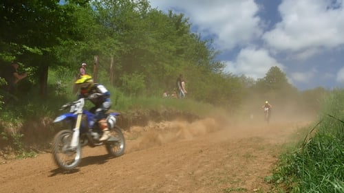 Motocross Racers Speeding Over Dirt Track Jump