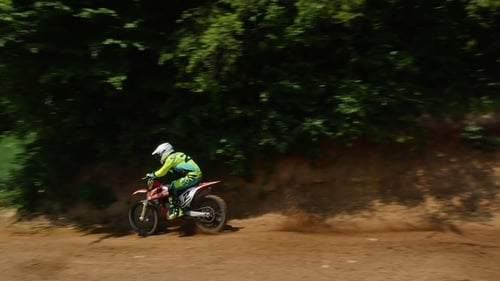 Motocross Riders Racing Down Dirt Track