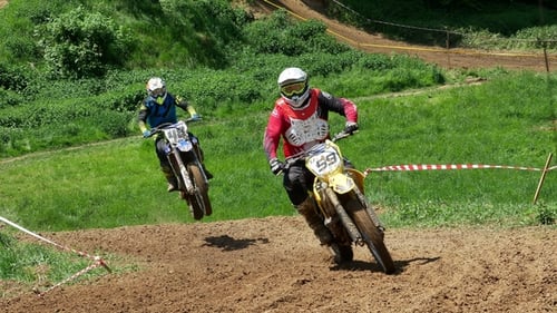 Motocross Racers Climbing a Hill on a Dirt Track