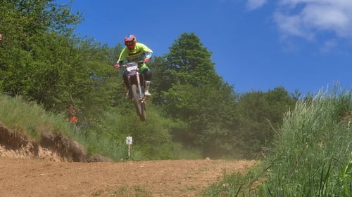 Motocross Rider Jumps on Dirt Track