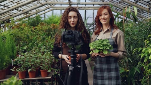 Women Filming Plant Vlog in Greenhouse