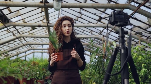 Woman Vlogging About Plants in a Greenhouse
