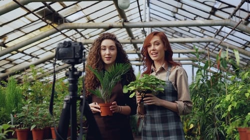 Women Gardening in Greenhouse Talking to Camera