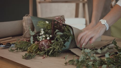 Florist Wrapping a Unique Bouquet with Paper and String