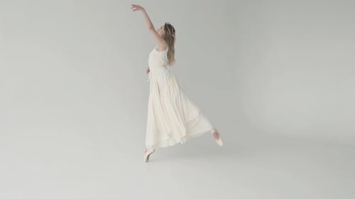 Graceful Ballerina Dancing in White Studio
