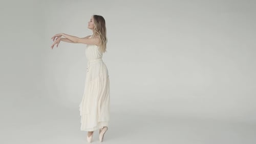 Graceful Ballerina Dancing in a White Studio