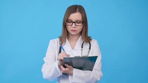 Friendly Woman Doctor Writing on a Clipboard