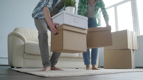 Couple Moving Boxes Into New Home Together