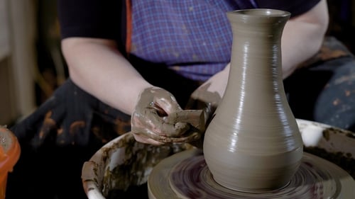 Crop Hands of Talented Potter façonne une belle cruche sur le tour de potier dans Craft Studio
