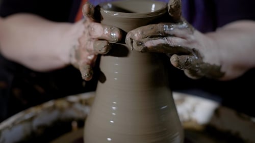Récoltez les mains fortes d'un maître talentueux façonnant de l'argile sur le tour de potier en atelier