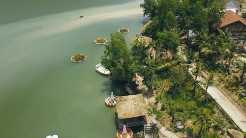 Bungalows with Thatched Roof and Wooden Pier for Boats on Shore Green Lake in Luxury Mountain Hotel