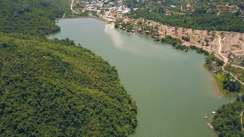 Aerial View Green Lake and Dam on Background Hills and Mountains Covered Ropical Forest. Flying