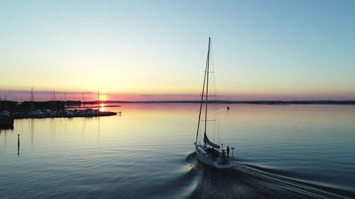 Sailboat Sailing in Calm Water During Sunset