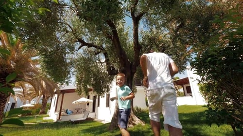 Father and Son Enjoying Time Together and Playing Tag in the Garden