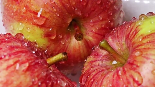 Rote saftige Äpfel in rotierenden Wassertropfen