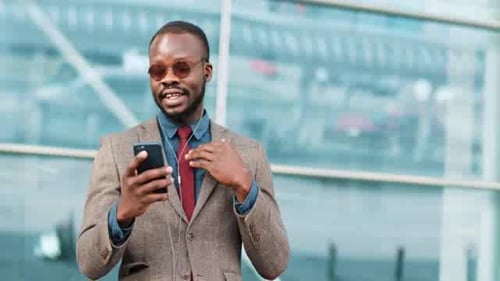 Man Video Conferencing on Phone Outside Building