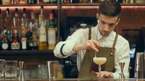 Bartender Preparing Cocktail with Precision in Bar