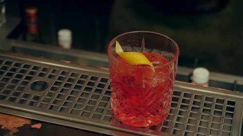 Bartender Hand Finish the Cocktail, Decorating It with Slice of Orange