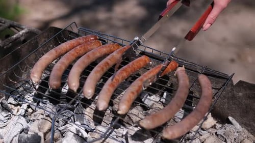 Vue en gros plan de délicieuses saucisses grillées sur la grille du gril à charbon