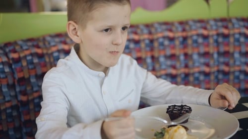 Handsome Smiling Boy Eating a Tasty Dessert in Cafe.