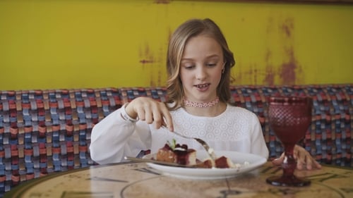 Girl Enjoying Cake in Colorful Restaurant