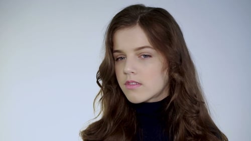Young Woman with Brown Hair Poses in Studio