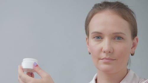 Young Woman Applying Moisturizer to Face