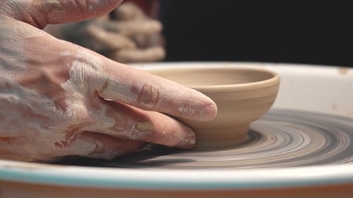 Potter Shaping Clay Bowl on Spinning Wheel