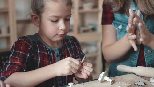 Child and Adult Making Clay Art Together