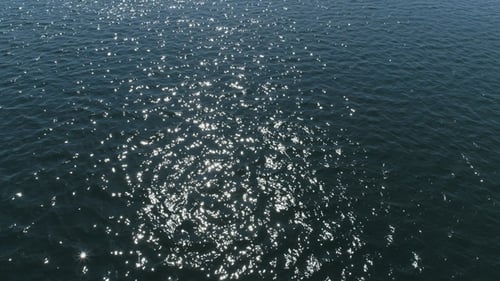Aerial View of Ocean with Sunlight and Boat