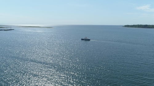 Boat Glides Across Sparkling Ocean on Sunny Day